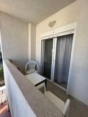 a balcony with a table and chairs and a window at Apartmani MiS in Dobra Voda
