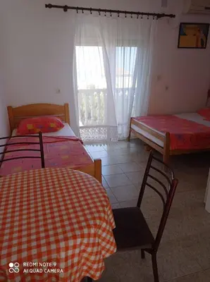 a bedroom with two beds and a table and chairs at Apartmani MiS in Dobra Voda
