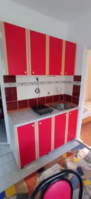 a kitchen with red cabinets and a sink at Apartmani MiS in Dobra Voda