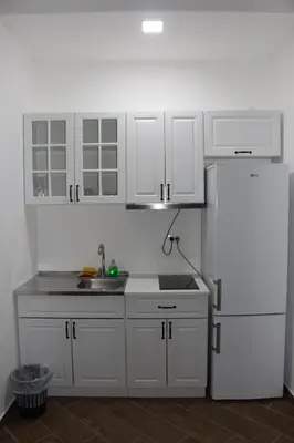 a kitchen with white cabinets and a white refrigerator at AMD - stan 314 in Dobra Voda