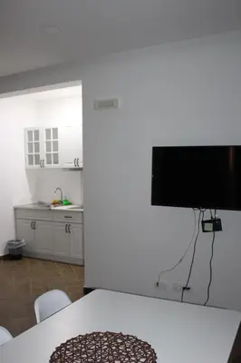 a kitchen with a table and a monitor on a wall at AMD - stan 314 in Dobra Voda