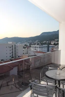 a balcony with tables and chairs on a building at AMD - stan 314 in Dobra Voda