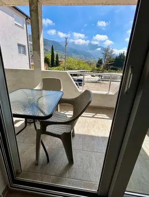 a table and a chair sitting on a balcony at Apartman Živaljević 3 Tivat in Tivat