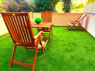 two chairs and a table with a plant on a lawn at Studio Apartman Stefana in Kravlja