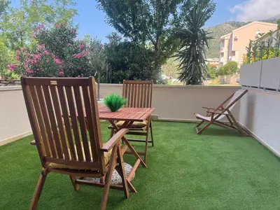 a patio with two chairs and a table with a plant at Studio Apartman Stefana in Kravlja