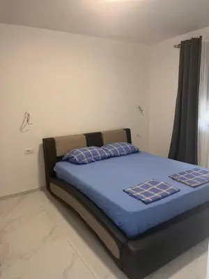 a bedroom with a bed with blue sheets and a window at BarDeluxe in Bar