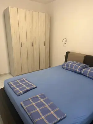 a bedroom with a bed with blue sheets and a cabinet at BarDeluxe in Bar