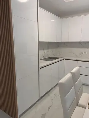 a white kitchen with white cabinets and a white chair at BarDeluxe in Bar