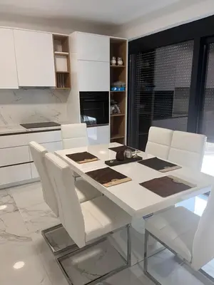 a kitchen with a white table and white chairs at BarDeluxe in Bar