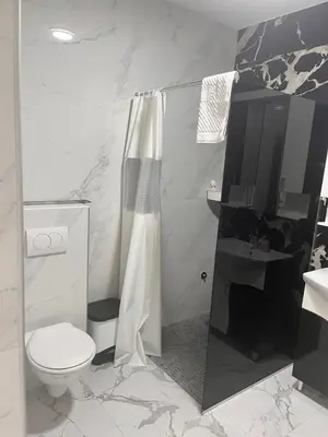 a bathroom with a shower and a toilet and a sink at BarDeluxe in Bar