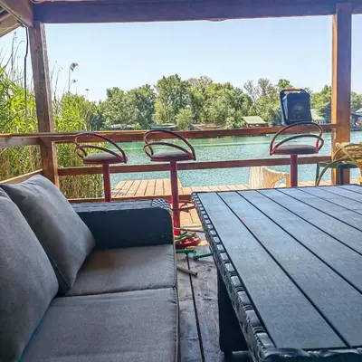 a couch on a porch with a table and chairs at River Escape Ada Bojana in Ulcinj