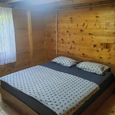a bedroom with a bed with a wooden wall at River Escape Ada Bojana in Ulcinj