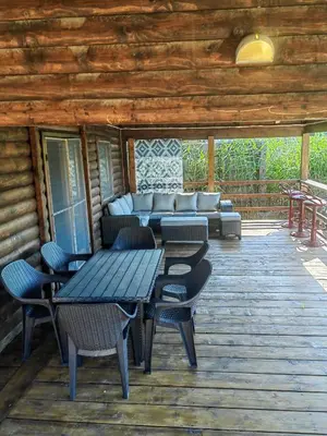 a deck with a table and chairs and a couch at River Escape Ada Bojana in Ulcinj