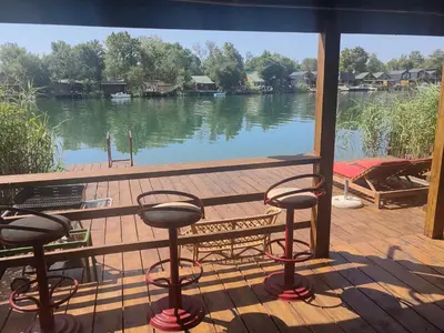 a view of a lake from a deck with stools at River Escape Ada Bojana in Ulcinj