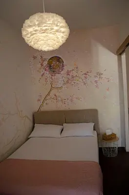 a bedroom with a bed with a flower mural on the wall at Apartman Staša in Kravlja