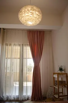 a large window with curtains and a chandelier at Apartman Staša in Kravlja