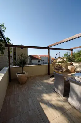 a patio with a table and chairs on a balcony at Apartman Staša in Kravlja