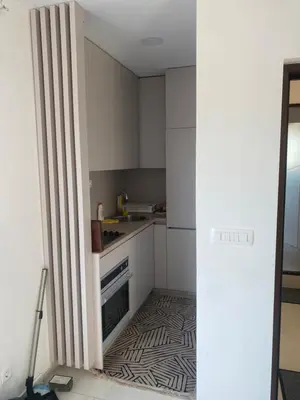 a kitchen with white cabinets and a black and white floor at Apartmani Hasanovic in Bar