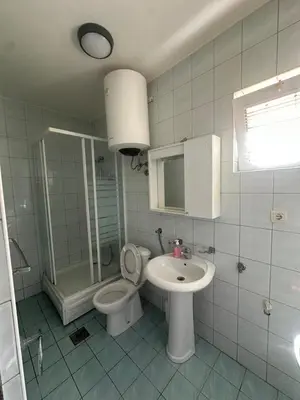 a white bathroom with a toilet and a sink at Antoni Apartments in Ulcinj
