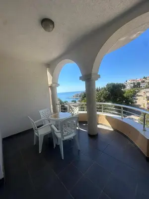 a balcony with a table and chairs and a view of the ocean at Antoni Apartments in Ulcinj
