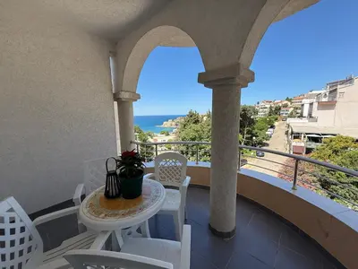 a balcony with a table and chairs and the ocean at Antoni Apartments in Ulcinj