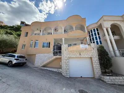 a house with a car parked in front of it at Antoni Apartments in Ulcinj