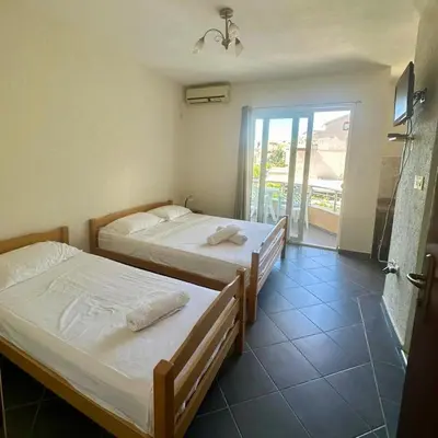 two beds in a room with a balcony at Antoni Apartments in Ulcinj