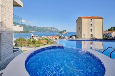 a swimming pool with a view of the water at Como Vista Apartments in Budva