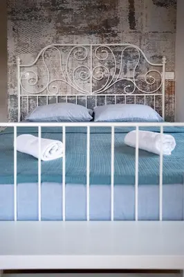 a bed with blue sheets and pillows on it at 086 Studio Apartment in Cetinje