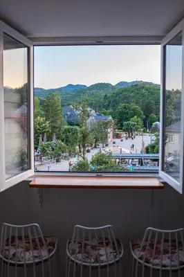 a window with two chairs looking out at a view at 086 Studio Apartment in Cetinje