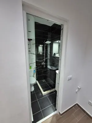 a bathroom with a toilet and a shower with black tiles at Ajum Apartments in Ulcinj