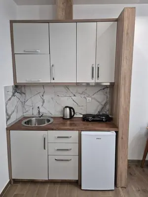 a kitchen with white cabinets and a sink at Ajum Apartments in Ulcinj