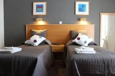 two beds sitting next to each other in a bedroom at Aurora suit in Podgorica