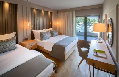 a hotel room with two beds and a desk at Aurora suit in Podgorica