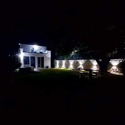 a house lit up at night with lights at House in Nature Milić in Čanj