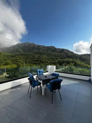 a table and chairs on a balcony with a mountain at House in Nature Milić in Čanj