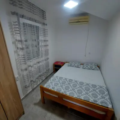 a small bedroom with a bed and a window at House in Nature Milić in Čanj