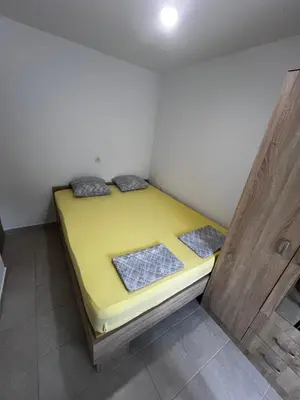 a small room with a yellow bed in the corner at House in Nature Milić in Čanj