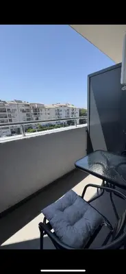 a balcony with a chair and a tv and a window at Lux stan in Bar
