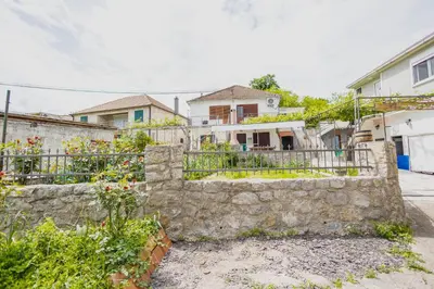 a stone retaining wall in front of a house at Montanica in Virpazar