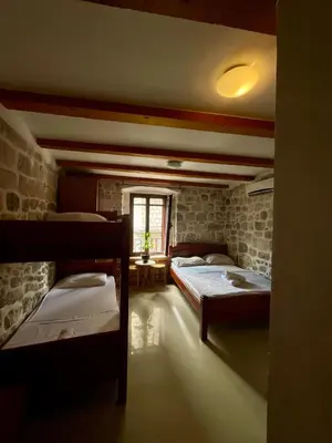 a room with three beds in it with a window at Square view in Kotor