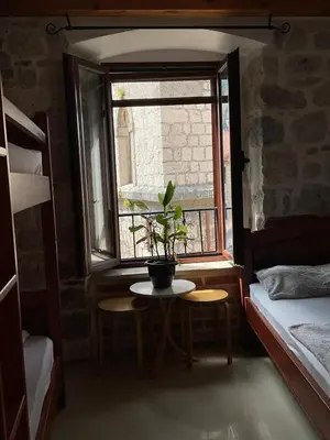 a room with a table and a window with a potted plant at Square view in Kotor