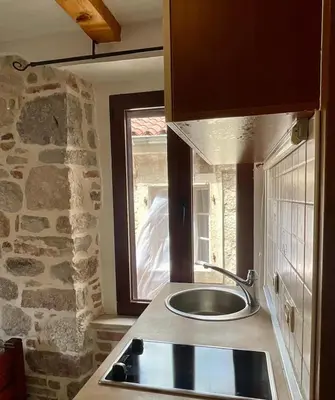 a kitchen with a sink and a stone wall at bella 11 in Kotor