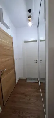 a hallway with a door and a light and a mirror at Harmoniya apartment in Bar