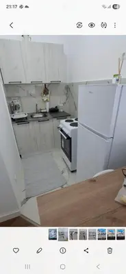 a white kitchen with a stove and a refrigerator at Harmoniya apartment in Bar