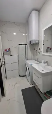 a white bathroom with a sink and a toilet at Harmoniya apartment in Bar