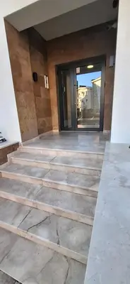 a staircase leading to a building with a glass door at Harmoniya apartment in Bar