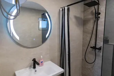 a bathroom with a shower and a sink and a mirror at Vila Luxembourg in Ulcinj