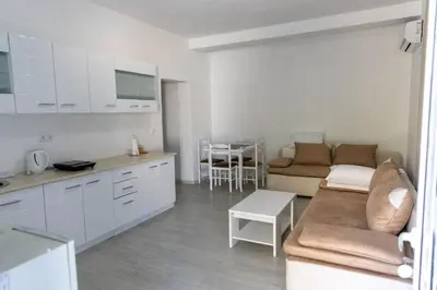 a kitchen and living room with a couch and a table at Vila Luxembourg in Ulcinj
