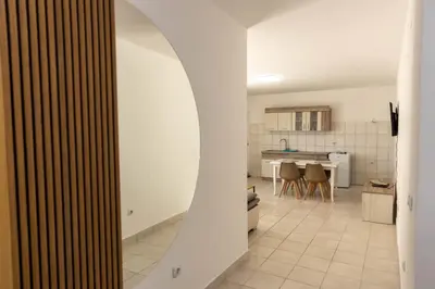 a kitchen with white walls and a white tile floor at Vila Luxembourg in Ulcinj